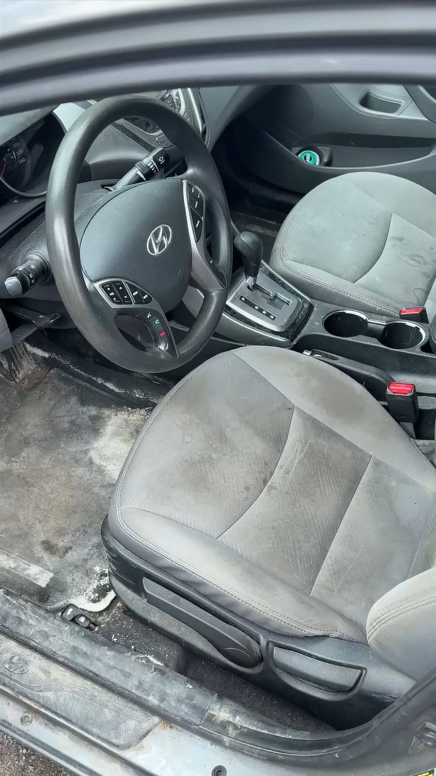 Stained car seat and dirty floor carpet before a professional pet odour interior detail